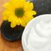 Basic White Cream in a bowl with stones and a calendula flower