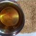 Bowl of sesame oil beside sesame seeds